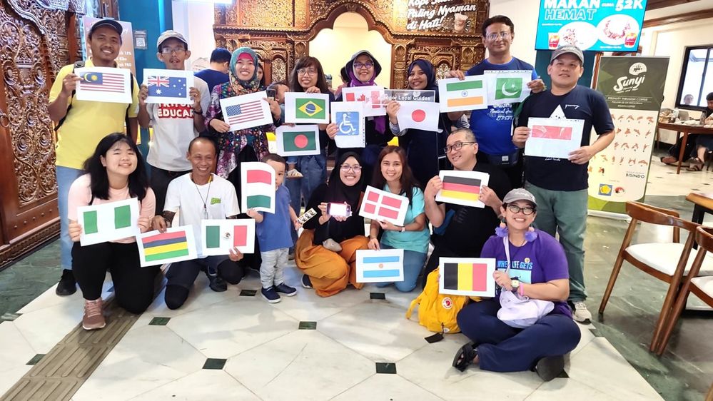 Caption: participants of Accessible Jakarta - WAW 2023 posed together with flags and signs