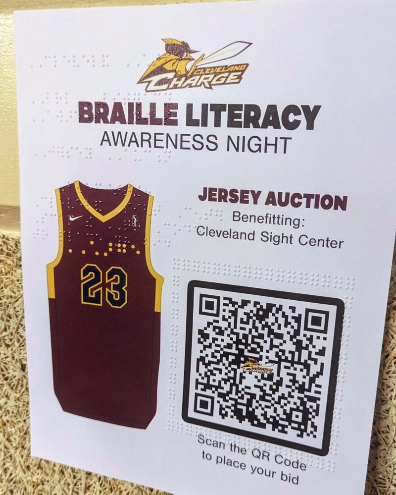 Caption: a photo of the legible braille poster promoting the jersey auction