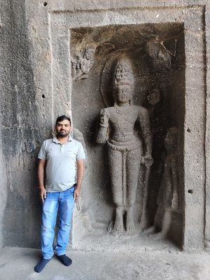 Photograph of LG NandKK beside a rock-cut statute of Lord Vishnu