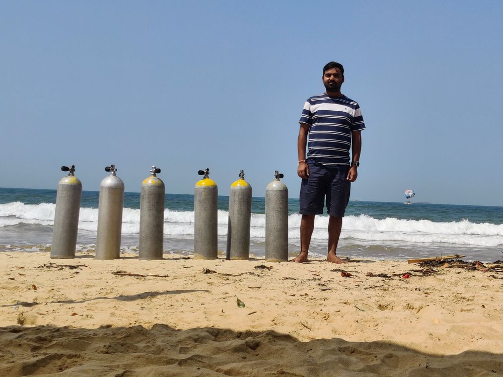 One person (LG @NandKK ) standing infront of a beach with 6 oxygen cylinders (Malvan beach) (photo by LG @NandKK)