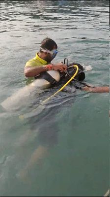 ​One person (LG @NandKK ) with scuba gears carrying away in the sea for diving by an instructor (photo by LG @NandKK)