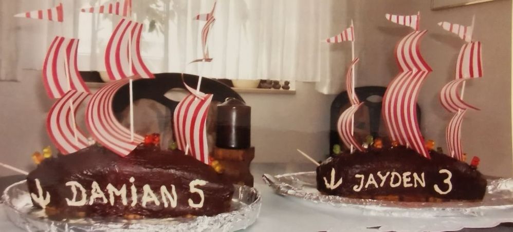 Caption: A photo of two chocolate cakes decorated as ships with the words “Damian, 5” and “Jayden, 3” on them. (Courtesy of Local Guide @Stephanie_OWL)