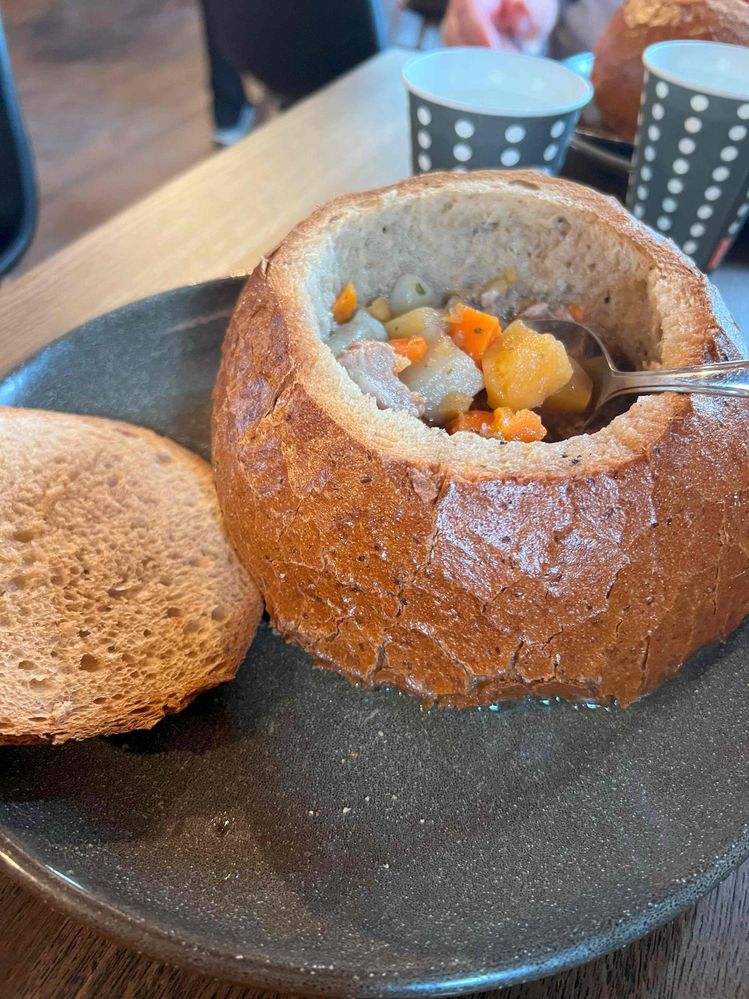 Caption: traditional lamb soup served in a bowl made of bread.
