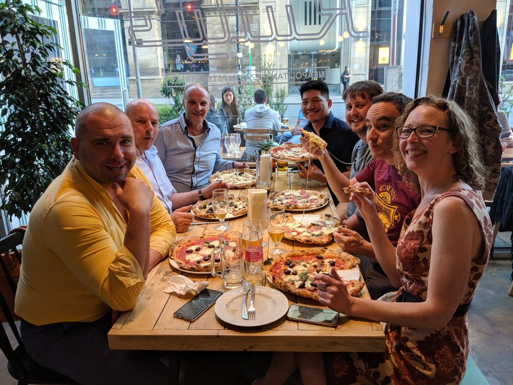 Caption: A photo of the Manchester Local Guides enjoying pizza during a photography food crawl. (Courtesy of Local Guide @PeteMHW)