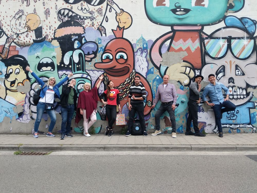 Caption: A photo of Pete and Local Guides from all over Europe at the second EuroMeetup in Ghent, Belgium, posing in front of a colorfully graffitied wall. (Courtesy of Local Guide @PeteMHW)