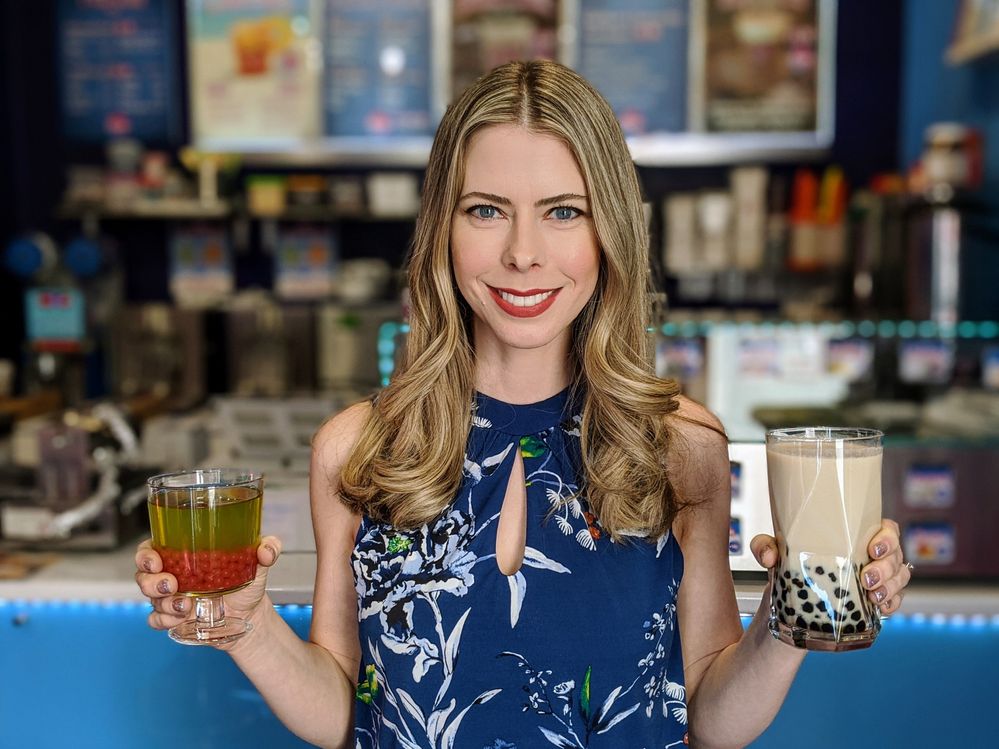Caption: A photo of Kristin smiling and holding two bubble tea drinks. (Courtesy of Local Guide @TheRealKristin)
