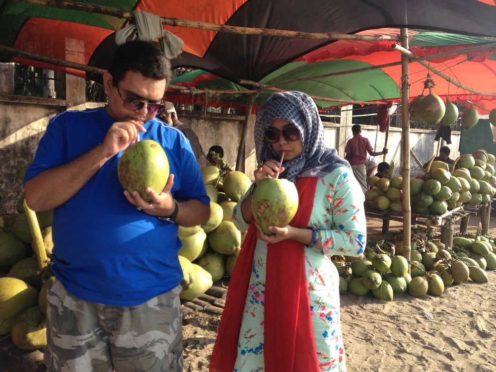 Local Guides Sumaiya and Pavel celebrating the new year with fresh coconut water at Inani Beach in Bangladesh