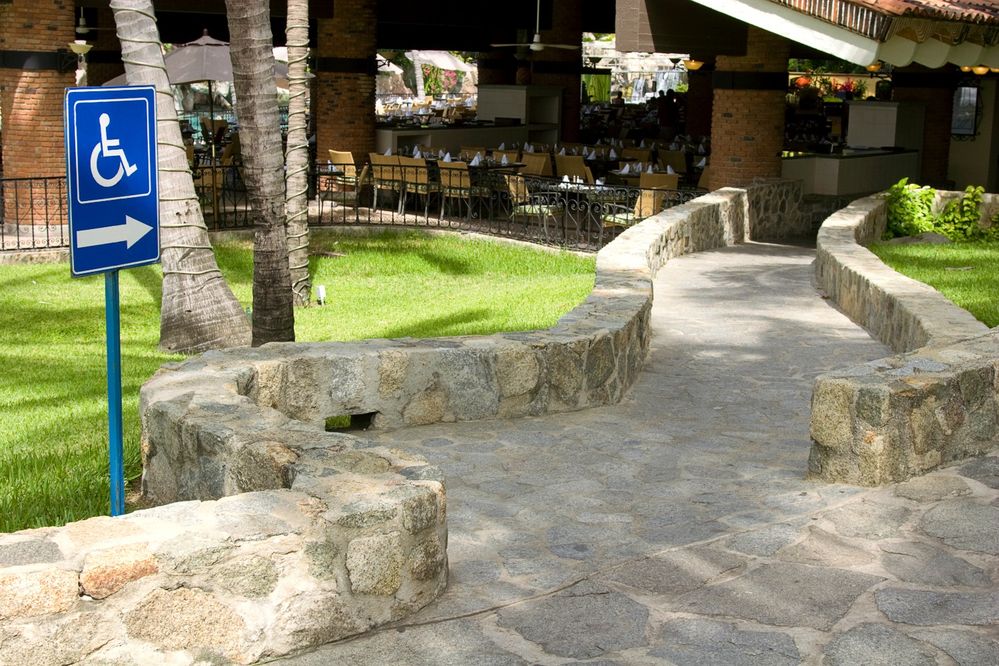 Caption: A wheelchair-accessible stone ramp leading to the entrance of an outdoor restaurant