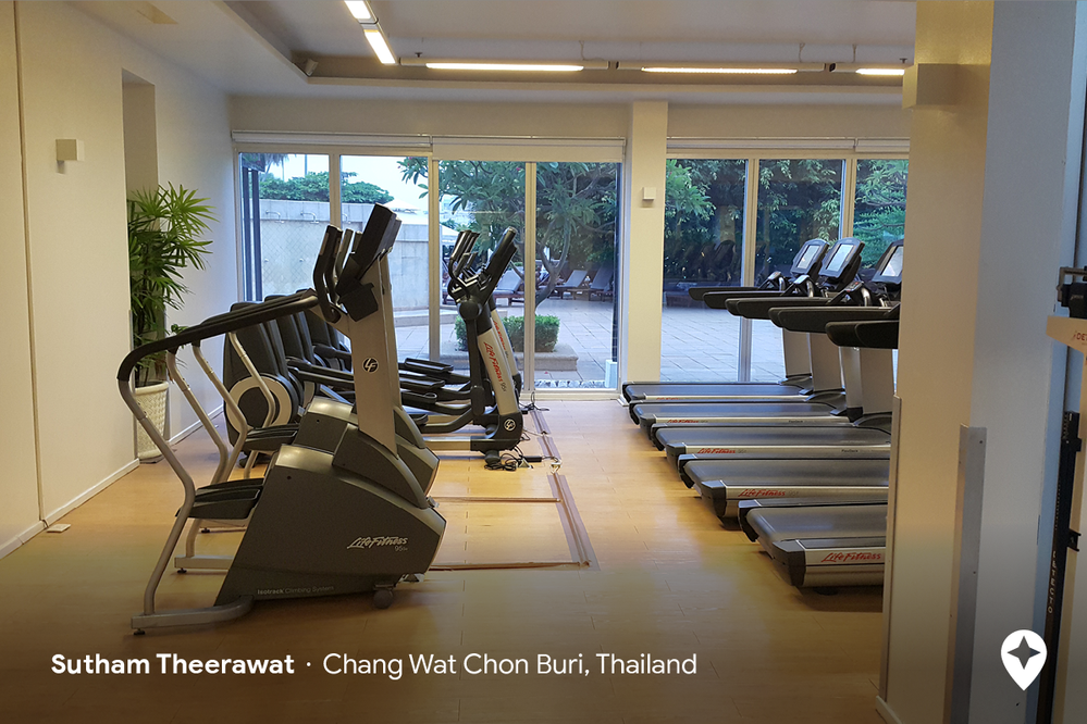 Caption: A photo of rows of stair steppers, ellipticals, and treadmills in a hotel gym in Chang Wat Chon Buri, Thailand (Local Guide Sutham Theerawat)