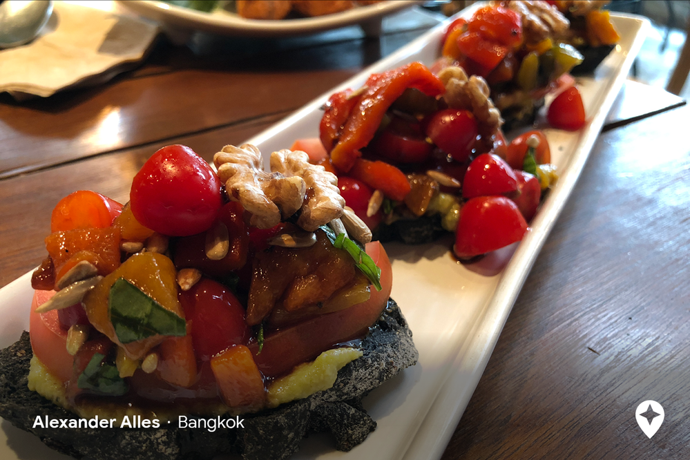 Caption: A photo of a vegetarian dish with tomatoes, avocado, and walnuts at a restaurant in Bangkok (Local Guide Alexander Alles)