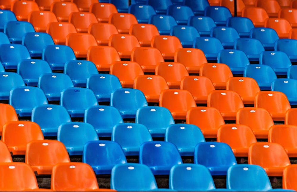 Caption: A photo of orange and blue stadium seats. (Getty Images)