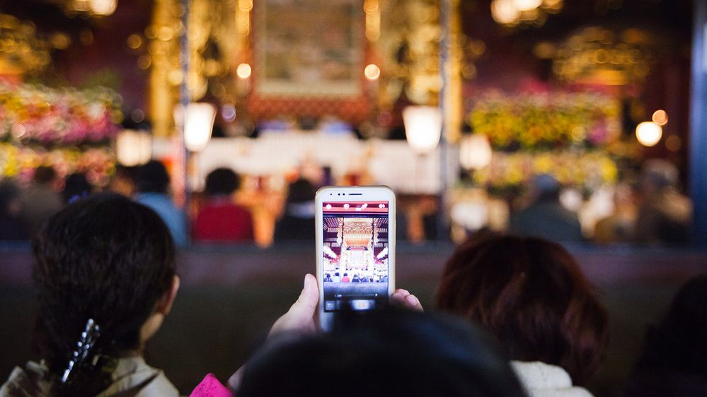 Caption: A photo of a woman photographing temple with a camera phone. (Getty Images)