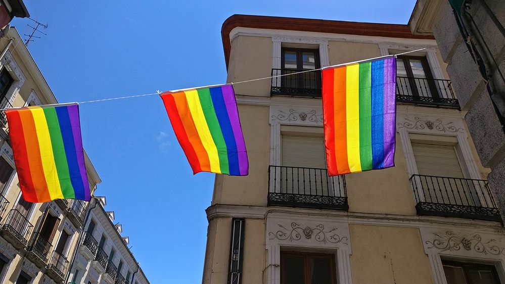 Caption: A photo of rainbow LGBTQ pride flags hanging against buildings in Madrid, Spain. (Local Guide Antonio Martinez)