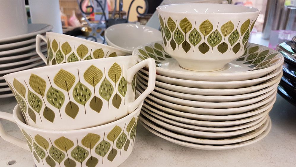 Caption: A photo of 1960s era coffee cups and saucers stacked on a shelf. (Local Guide Nancy Josland Dalsin)