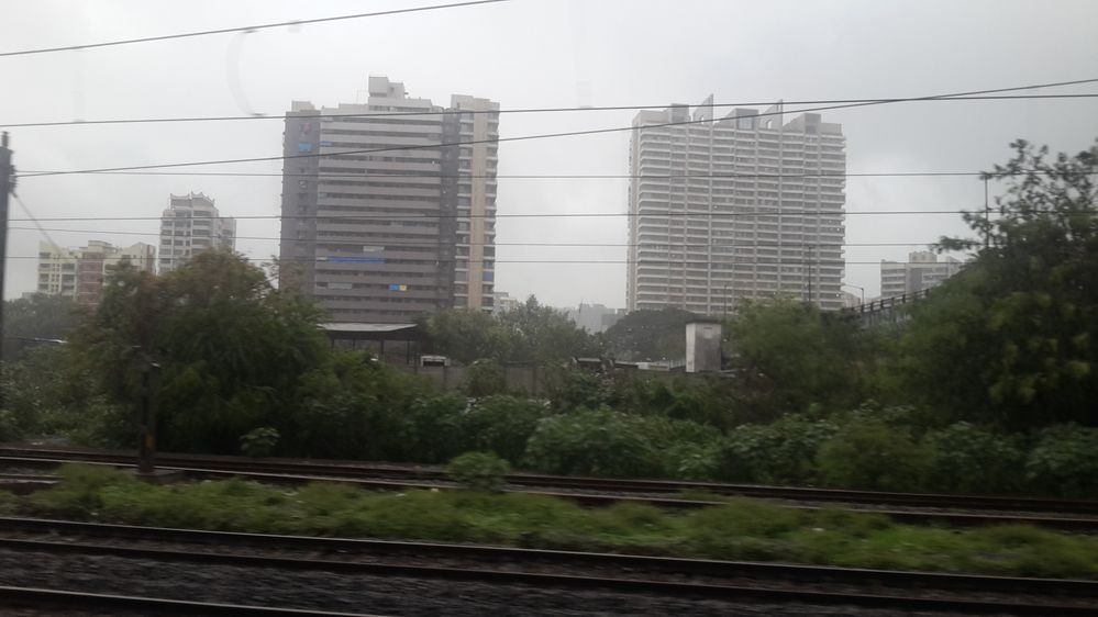 This photograph was taken from train at approximately at 7.45pm from train when about to reach Kandivli ,heavy rainfall with dense clouds in sky .This is monsoon season which has started in Mumbai.