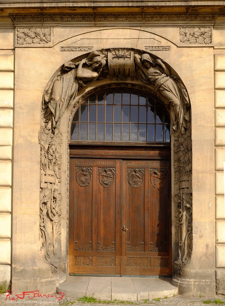 Carved sandstone doorway with oak doors.