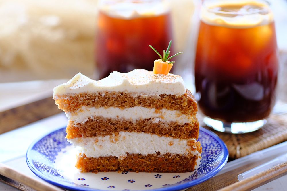 Caption: A photo of a slice of carrot cake on a plate with coffee at 그리울땐 제주 in Nago, Japan. (Local Guide Yangnam Kim)