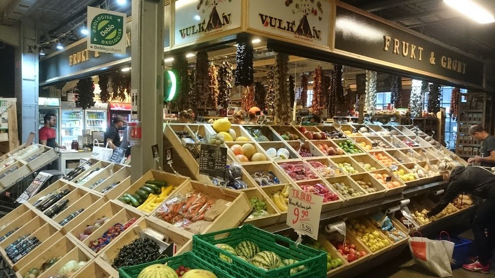 Caption: A photo of a stall filled with wooden crates of fruits and vegetables at Mathallen Oslo in Oslo, Norway. (Local Guide Jan Petter Hansen)