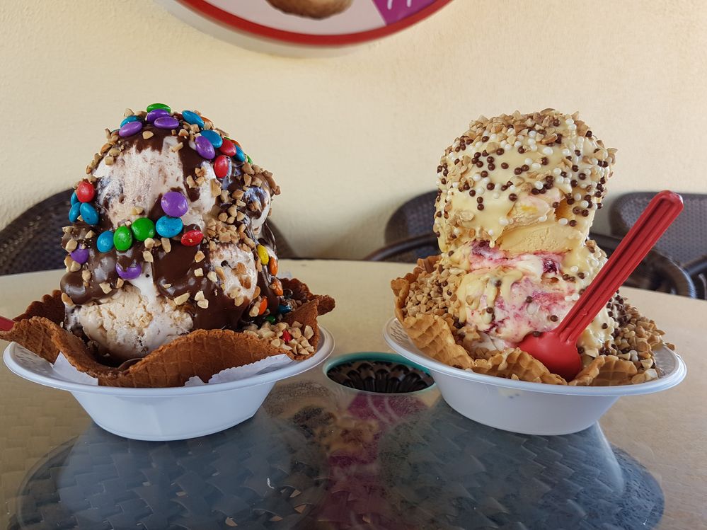 Caption: A photo of two ice cream sundaes in cups lined with waffle cone that contains two big scoops of ice cream, chocolate sauce, sprinkles and other candy toppings (Local Guide Victor Verona)