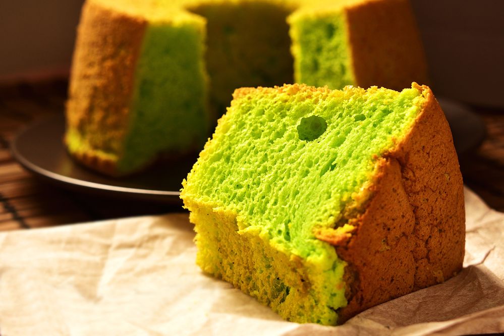 Caption: A photo of a slice of pandan cake in front of a plate of the rest of the cake. (Getty Images)