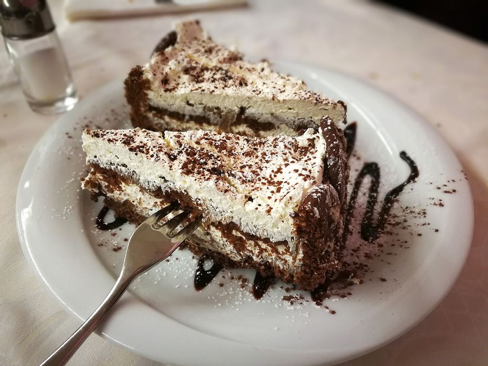 Caption: A photo of two slices of tiramisu on a place with a fork in one of them. (Local Guide Ivan Cirillo)