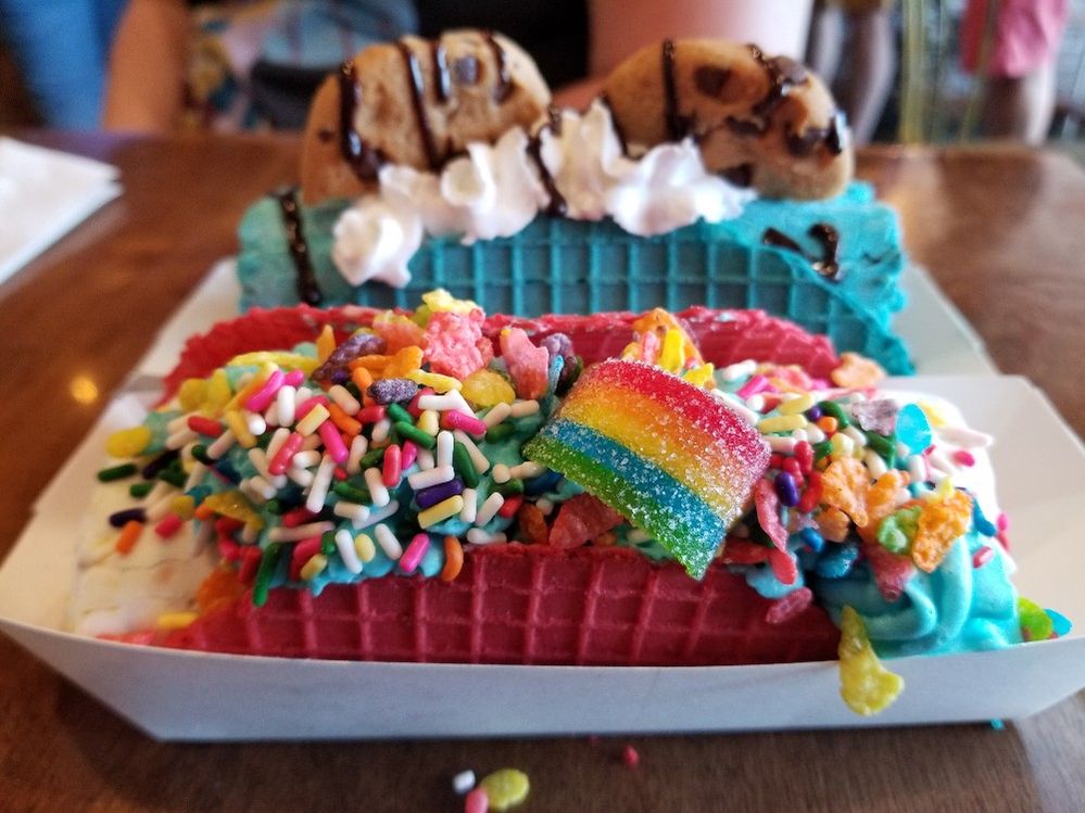 Caption: A photo of brightly-colored pink and blue waffle cone “tacos” filled with ice cream and topped with multi-colored sprinkles, candy, cookies, and whipped cream from Sweet Rolled Tacos in Garden Grove, California. (Local Guide Sheila Sutton)