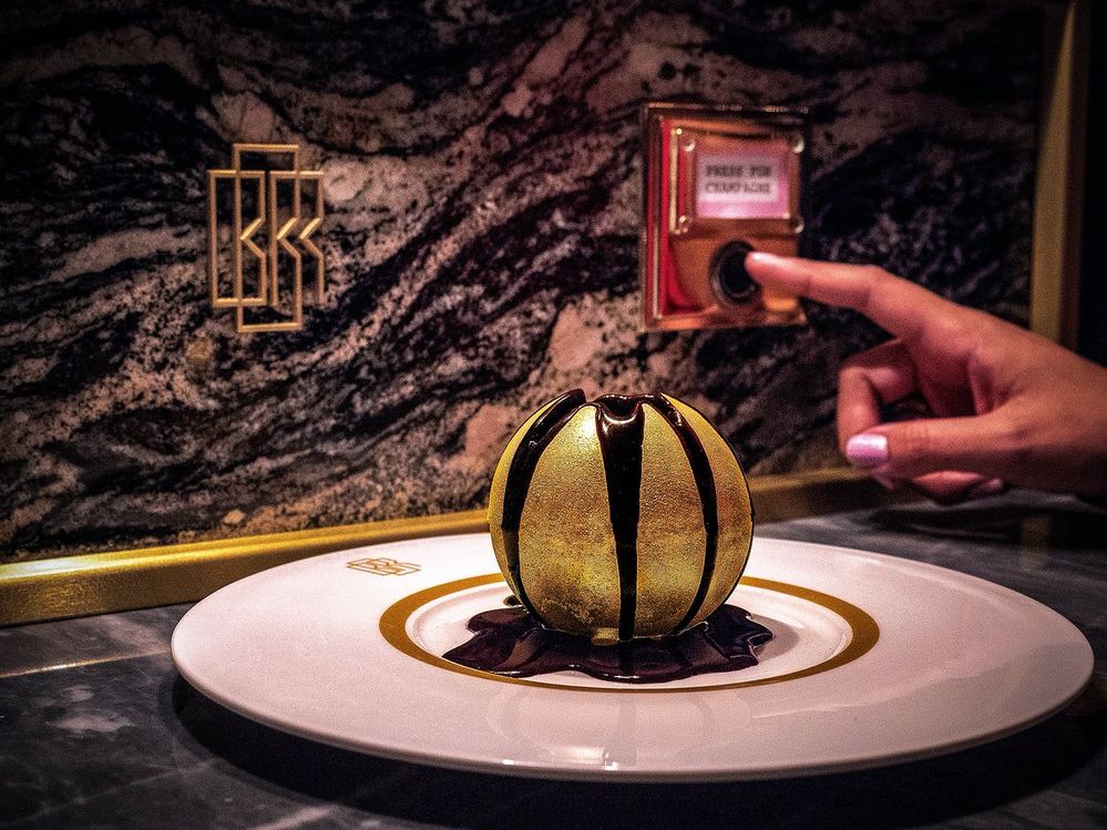 Caption: A photo of restaurant Bob Bob Ricard’s “Chocolate Glory” dessert, which features a gold-dusted sphere of chocolate with hot chocolate streaming down the sides, melting it to reveal the treats inside. (Local Guide Hitesh Choudhary)