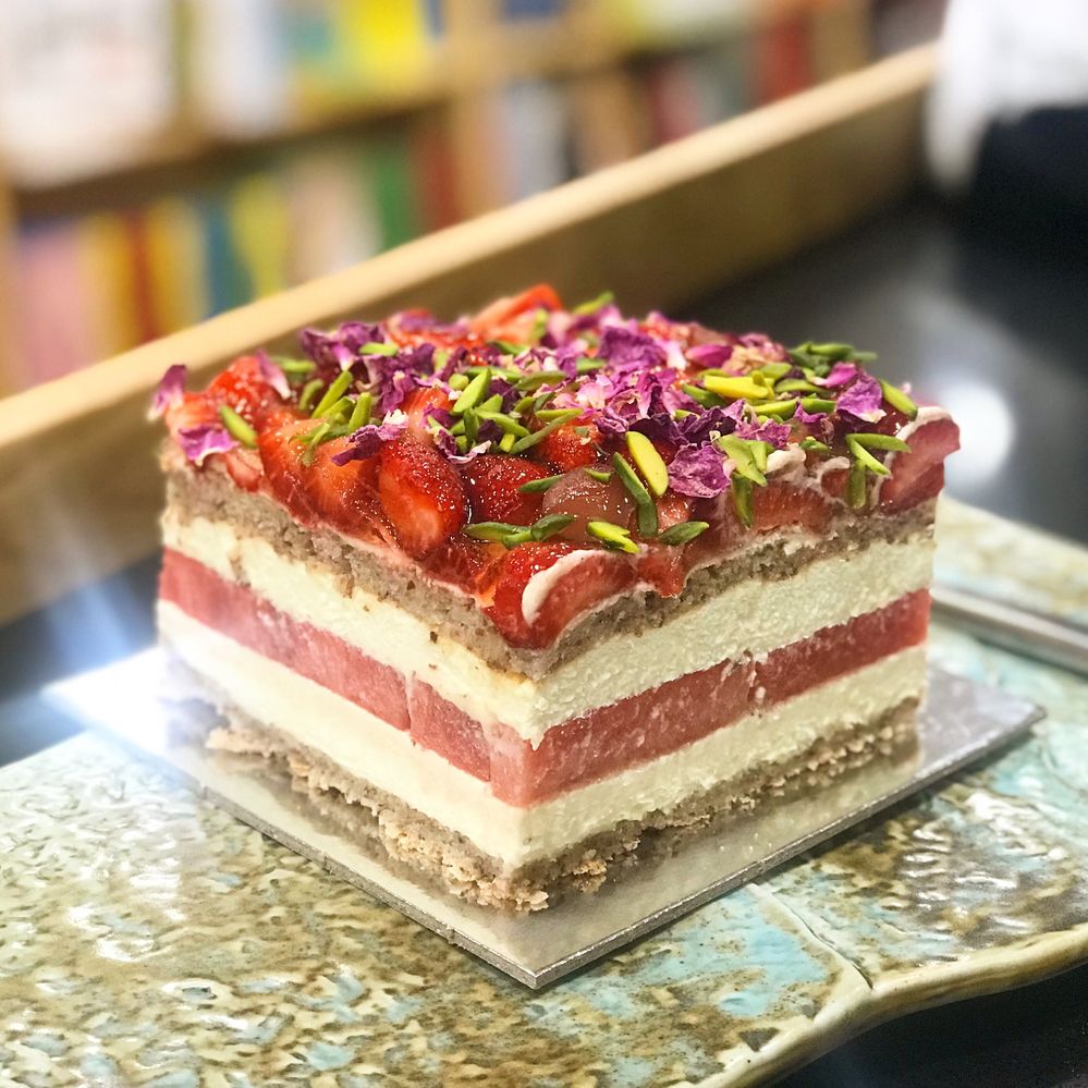 Caption: A photo of Sydney pastry shop Black Star Pastry’s strawberry watermelon cake, which consists of layers of a type of almond meringue, rose-scented cream, watermelon, and strawberries, topped with pistachios and dried rose petals. (Local Guide Christine Lee)