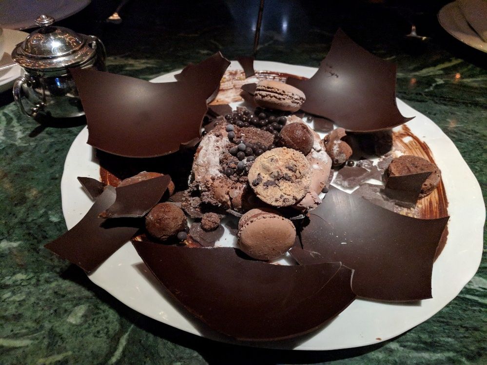 Caption: A photo of Amsterdam restaurant The Duchess’s “Chocolate Explosion” dessert, which features a smashed chocolate shell filled with chocolate cookies, mousse, and more chocolate. (Local Guide Devin Kanzler)