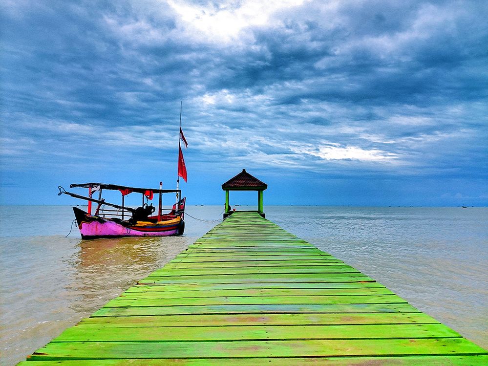 Caption: A photo of a dock and boat in the water.  View from Karang Jahe Beach, Rembang, Indonesia. (Local Guide Aab Abdillah)
