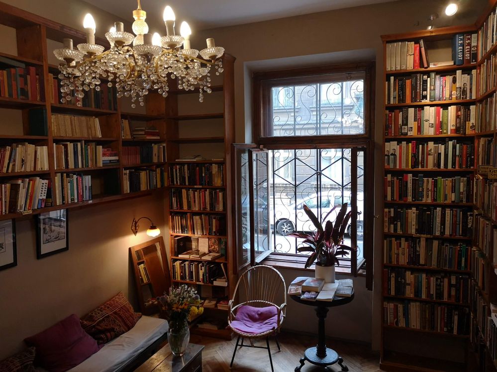Caption: A photo of a room in Massolit Books & Café featuring many bookcases, an open window, and a seating area.  (Local Guide Iwona Pobereznyk)
