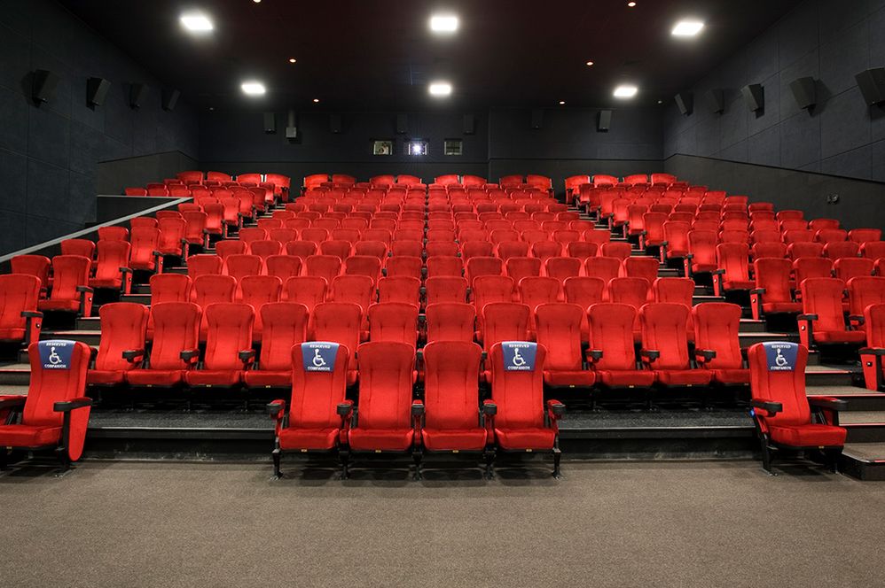 Caption: A photo of seating in a theater with seats designated for people who use wheelchairs. (Getty Images)