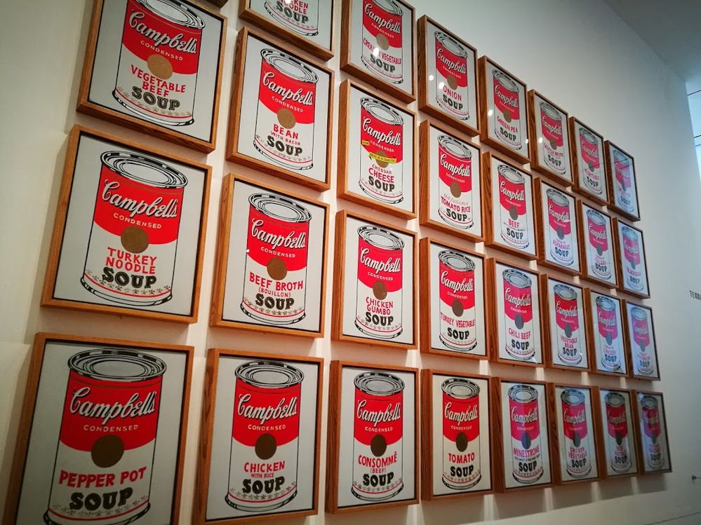 Caption: A photo of Andy Warhol’s painting “Campbell's Soup Cans,” an art piece that is made up of 32 paintings of different types of red and white Campbell soup cans, on display at MoMa in New York City. (Local Guide Alberto Gagna)