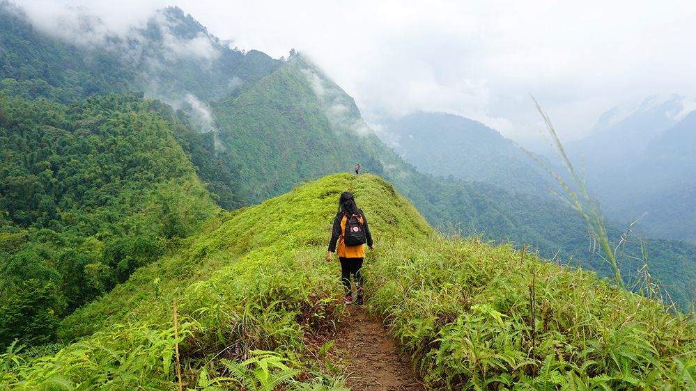 Caption: A photo of the back of a hiker on a trail on a mountain range in Bukit Watu Jengger, East Java, Indonesia. (Local Guide Rilly Jønamika)