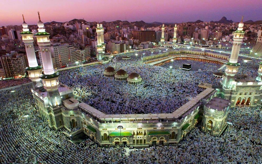 Caption: A photo of the Great Mosque of Mecca surrounded by people, taken at night. (Local Guide MUHAMMAD KASHIF ABRAR)