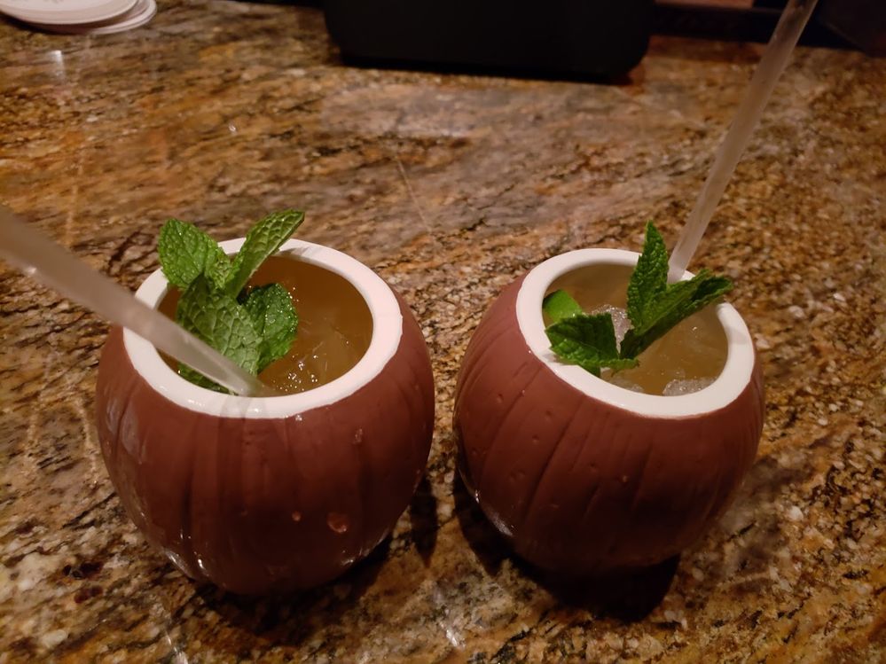 A photo of two mai tais in coconut shaped cups with straws on a table at Tonga Room & Hurricane Bar in San Francisco, California. (Local Guide Tanya Ayzikovich)