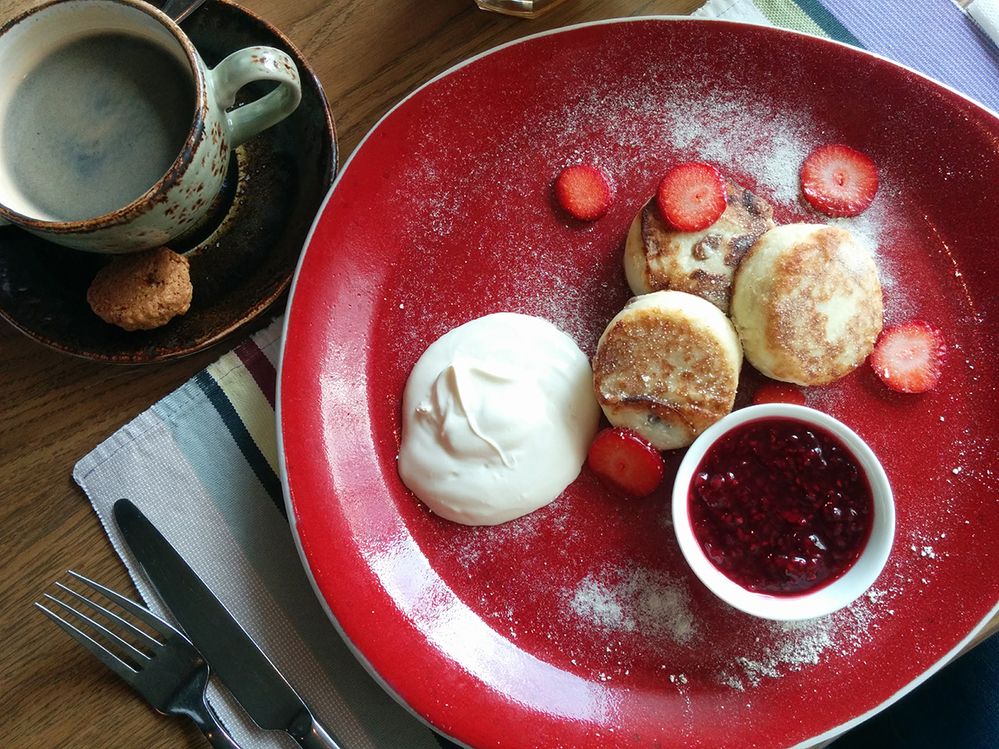 Caption: A photo of a coffee and cakes on a plate with cream, strawberries, and jam at Brichmula in St. Petersburg. (Local Guide Albina Akhmetshina)