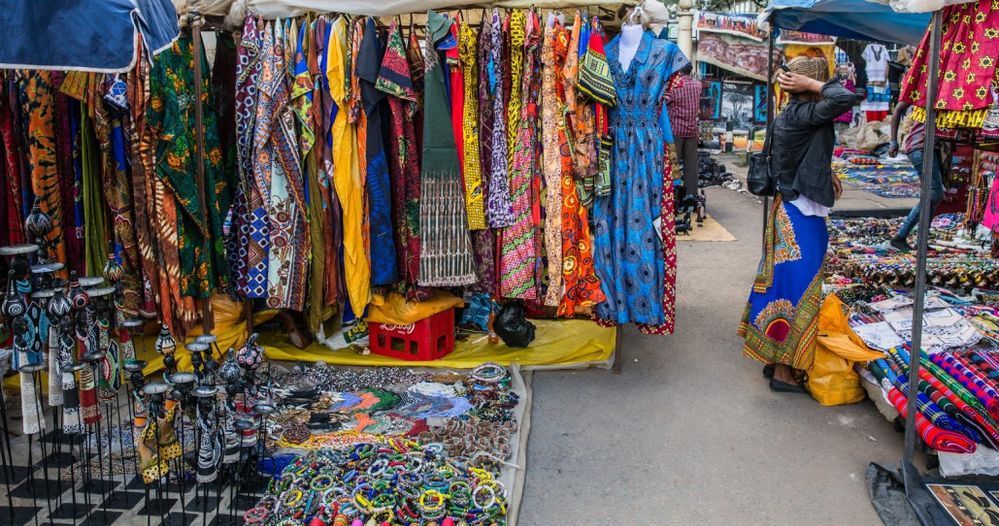 Caption: A photo of Maasai Market in Nairobi, Kenya filled with colorful garments. (Local Guide @WaweruM)