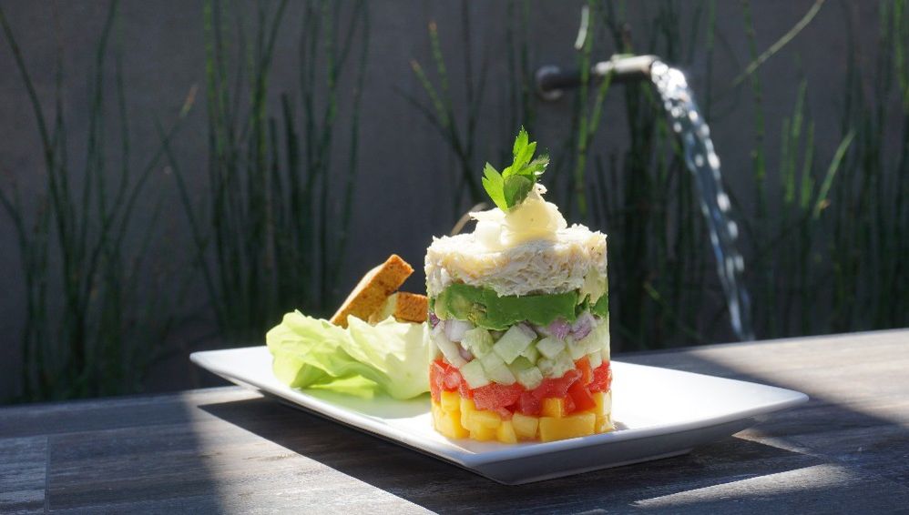 Caption: A photo of a stack of chopped mango, cucumber, avocado, onion, bell pepper, and crab meat on a plate served next to butter lettuce from 2Good2B in San Diego, California, United States. (Local Guide Diana Duangnet)