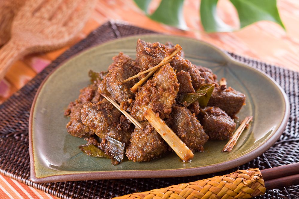 Caption: A photo of “rendang,” an Indonesian beef stew, on a green, leaf shaped plate. (Getty Images)