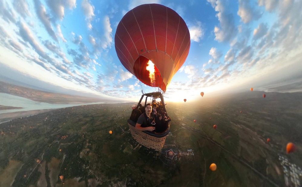 Caption: A 360 photo of Dimitar Karanikolov in a hot air balloon filled with other people in Bagan, Myanmar during sunrise on a partly cloudy day. (Courtesy of Dimitar Karanikolov)