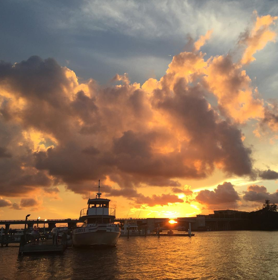 Caption: A photo of a bridge, boats, and a sunset in Jupiter, Fla.