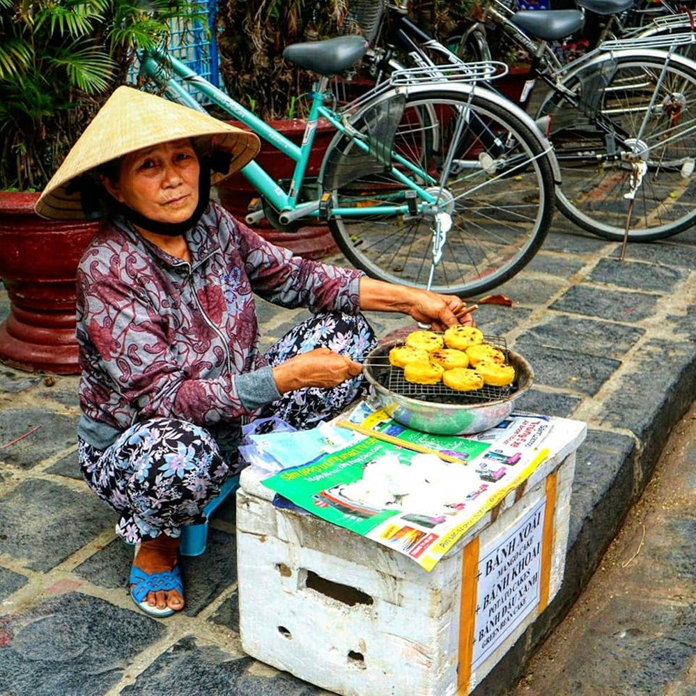 Vietnamese women who were selling on the edge of the street in Hoi An city with typical farmer hats