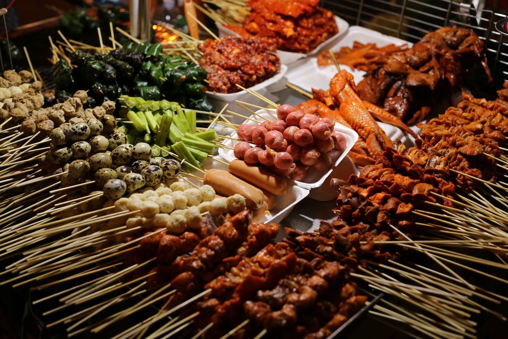 Caption: A photo of skewers of meat, seafood, and vegetables at a stand at Chợ đêm Đà Lạt in Da Lat, Vietnam. (Local Guide Yingchen Liu)