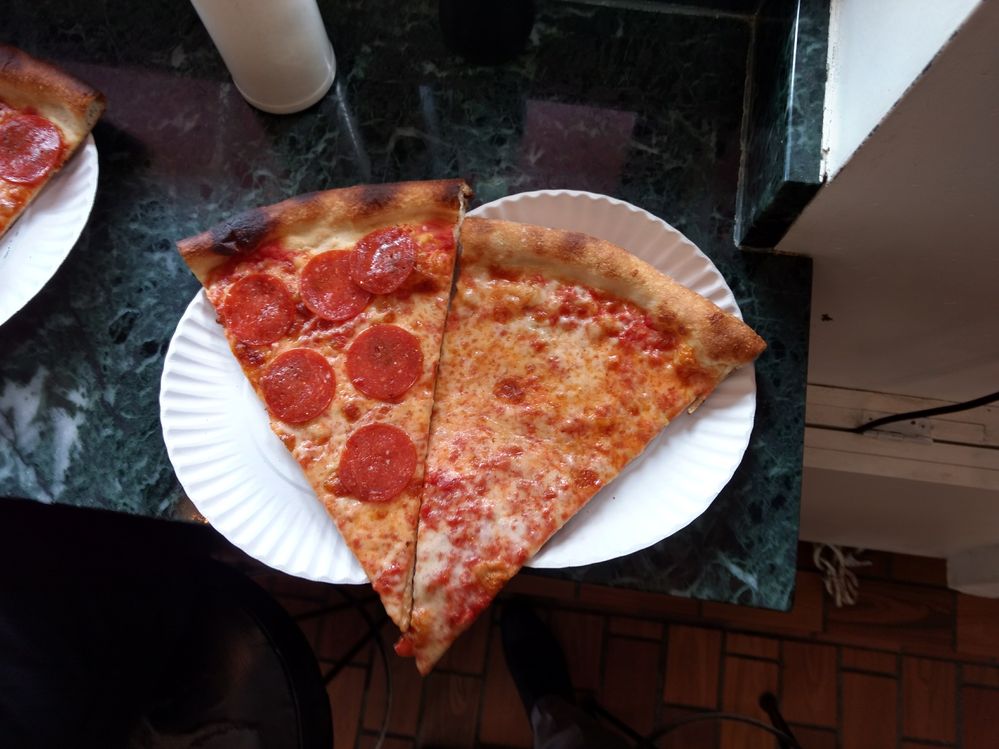Caption: A photo of one pepperoni and one cheese New York-style pizza slices on paper plates at Joe’s Pizza in Brooklyn, New York, USA. (Local Guide Carlos Sardi)