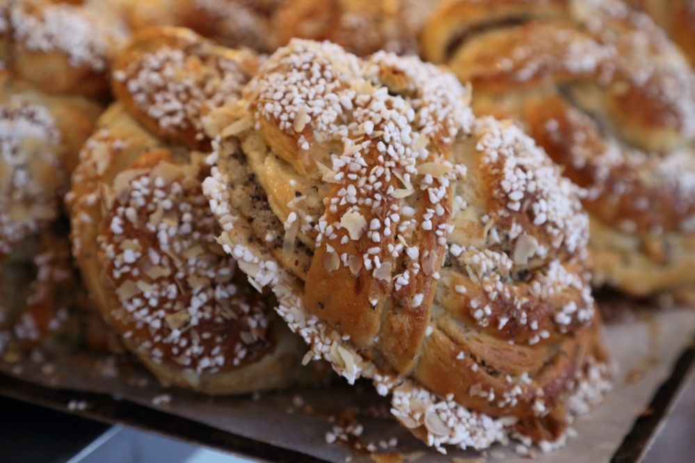 Caption: A close-up photo of a large kanelbullar, a type of Swedish cinnamon roll studded with sugar crystals, at Cafe Saturnus in Stockholm, Sweden. (Local Guide Truls Busch-Christensen)