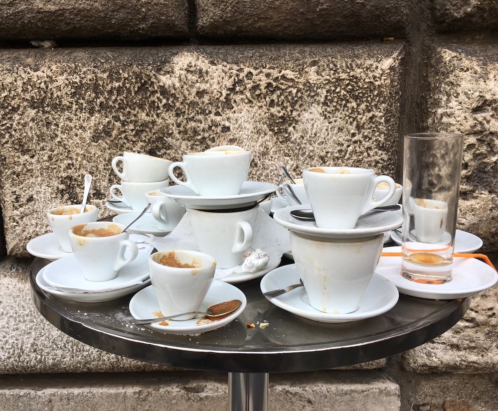 Caption: A photo of many empty white cups of coffee and saucers piled on top of each on a table at Sant' Eustachio Il Caffè in Rome, Italy. (Local Guide Dominic Baldemor)