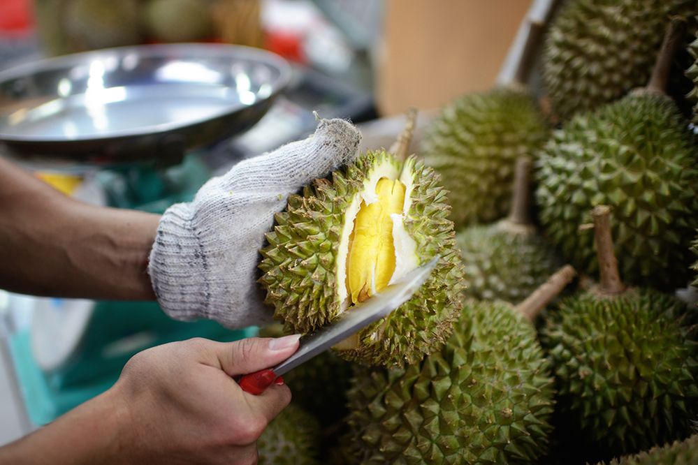 Caption: A photo of a fruit vendor opening a fresh durian. (Getty Images)