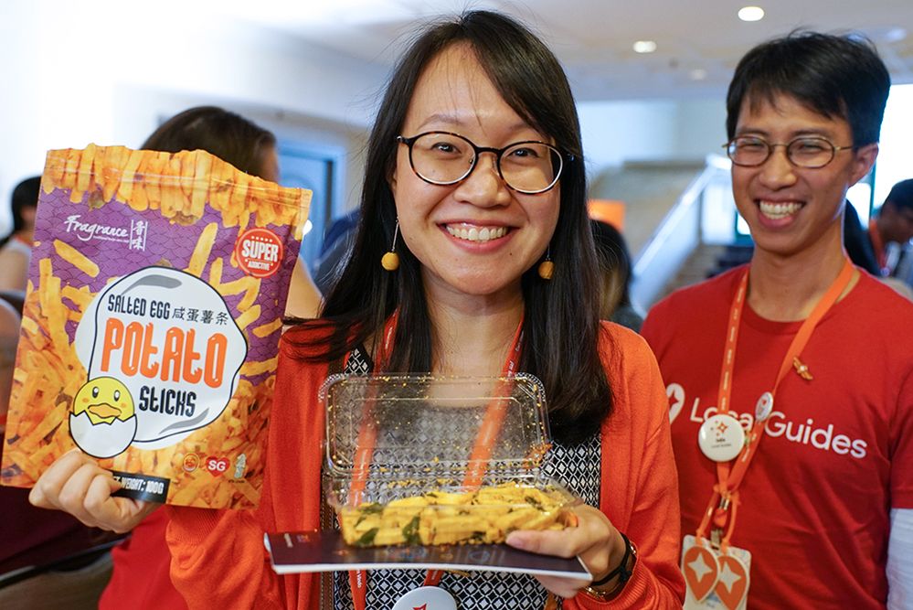 Caption: A photo of Local Guide Sarah holding up potato sticks flavored with salted duck egg at Connect Live 2018.