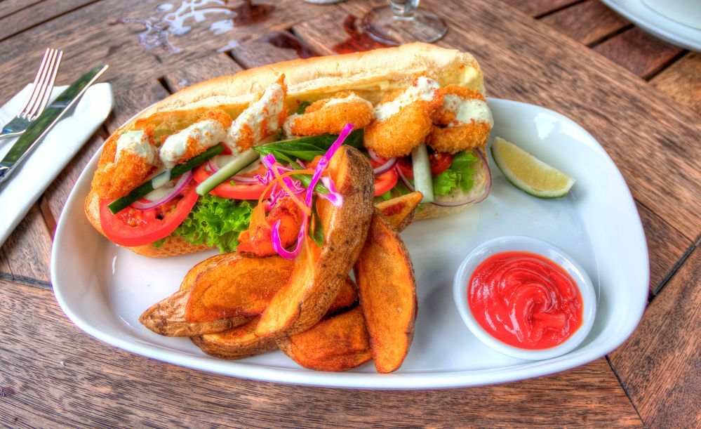 Caption: A shrimp po’ boy with a side of fries on a white plate with ketchup. (Local Guide @Nick-Hobgood)